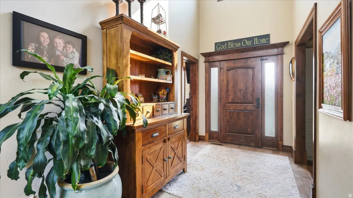 Welcoming foyer showcasing rich wood cabinetry with X-panel detailing, open shelving, and drawer storage
