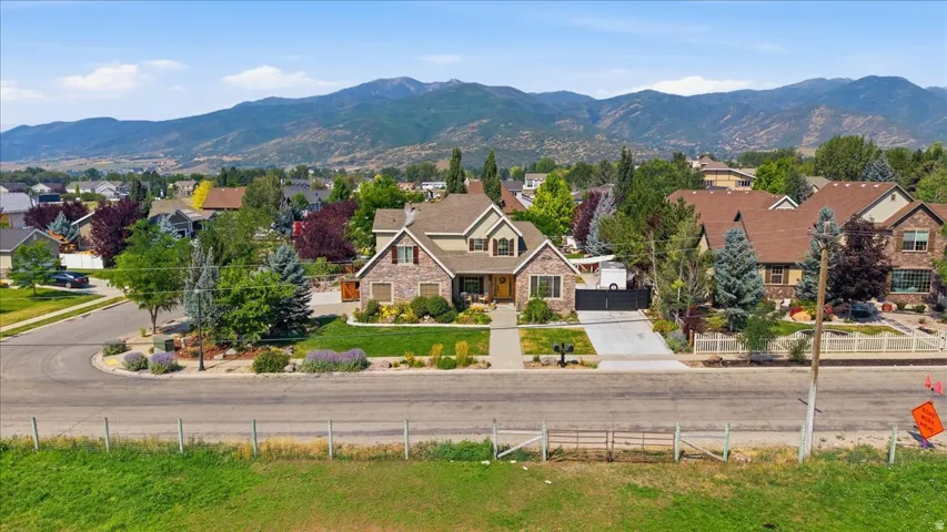 Elegant two-story residence featuring a composite or stone exterior with multiple peaked rooflines and architectural detailing