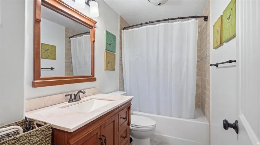 Spa-inspired bathroom featuring a wood-finish vanity with dual-sink configuration, white quartz countertop, and oil-rubbed bronze faucet hardware
