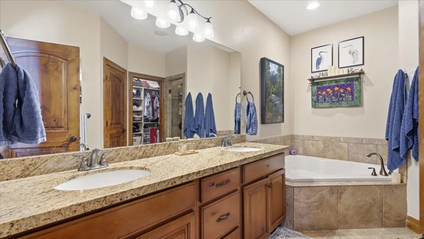 Luxurious master bathroom featuring dual vanities with granite countertops, an undermount sink, and oil-rubbed bronze fixtures