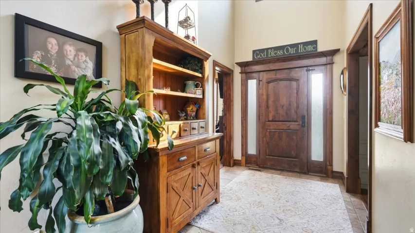 Welcoming foyer showcasing rich wood cabinetry with X-panel detailing, open shelving, and drawer storage