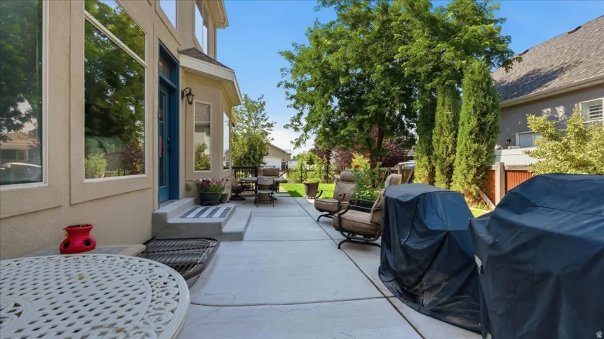 Rear patio featuring a concrete surface, exterior steps, and a blue painted door