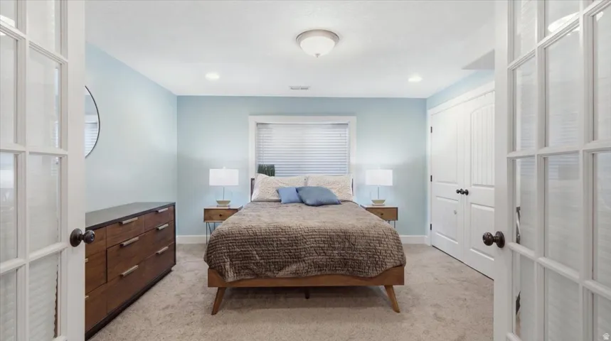 Primary Bedroom featuring light blue walls, recessed ceiling lighting, wood-finish flooring, and carpet throughout