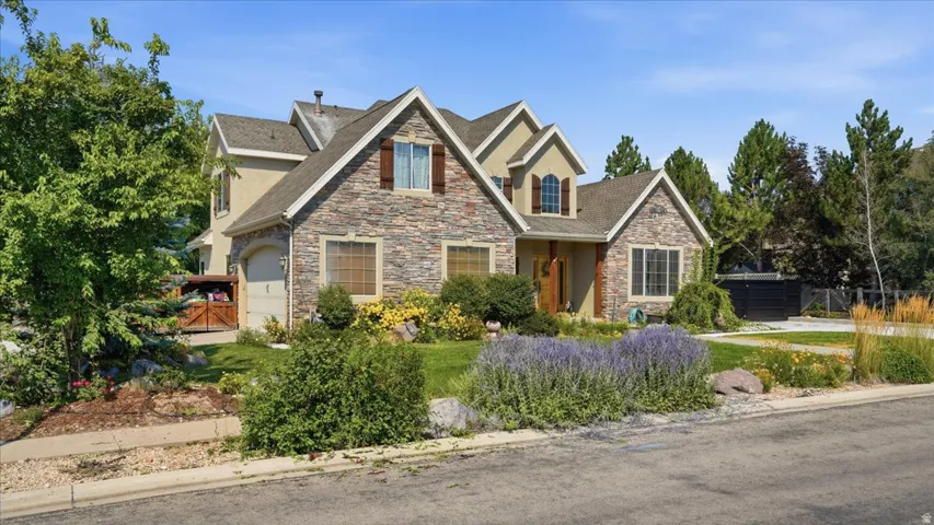 Elegant two-story residence featuring a mixed-material exterior of stone and brick with multiple gabled rooflines and arched architectural details