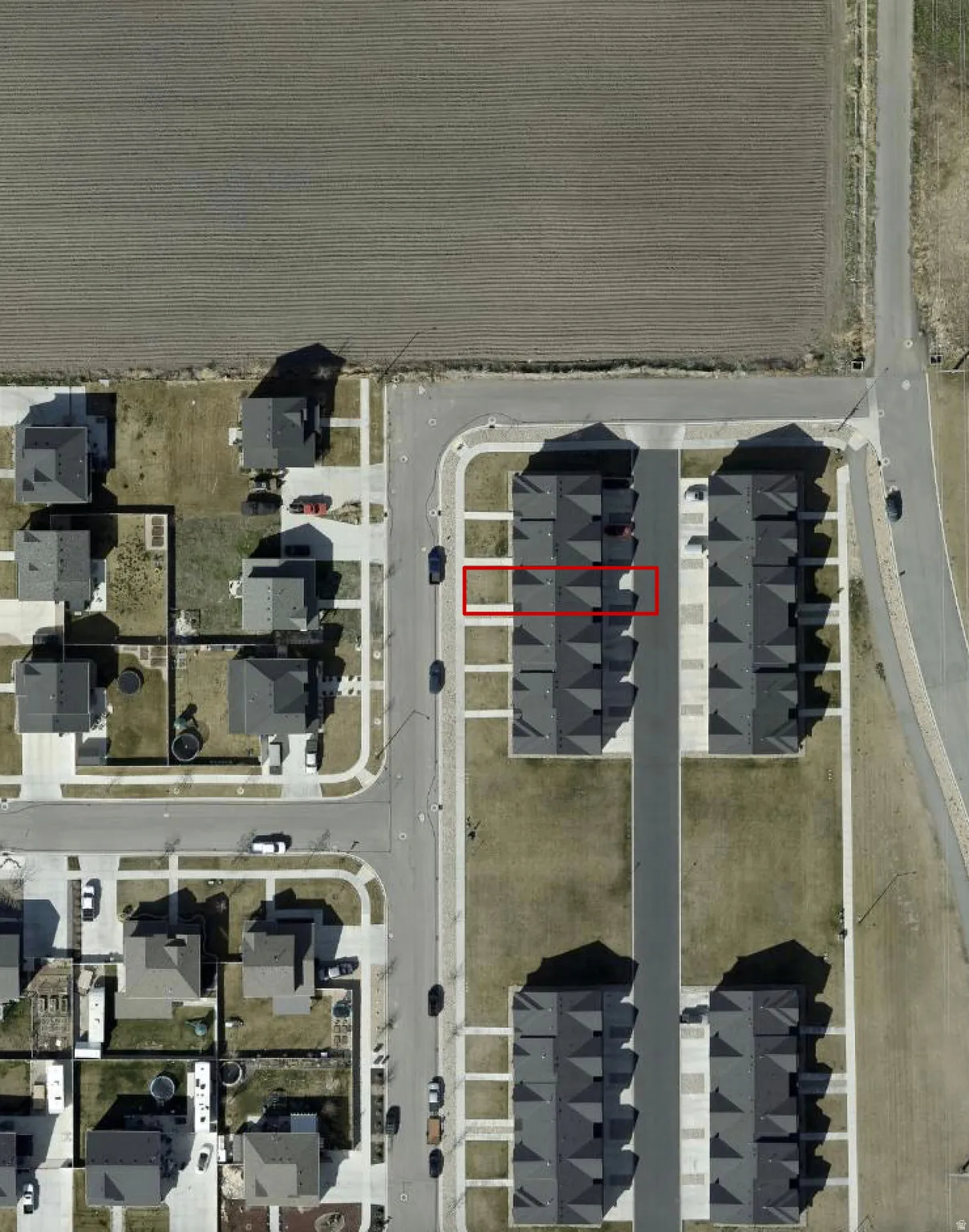 Aerial view of a residential area featuring a distinct property highlighted in red