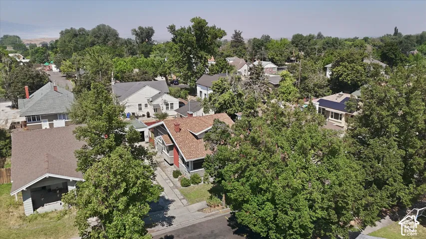 Aerial view showcasing this residential property nestled within a mature tree-lined setting