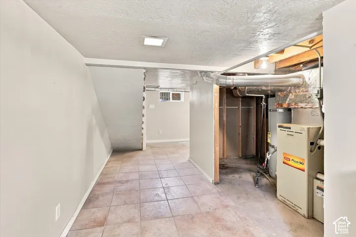 Finished basement offering versatile living space with ceramic tile flooring, recessed ceiling lighting, and utility infrastructure including HVAC system and appliances