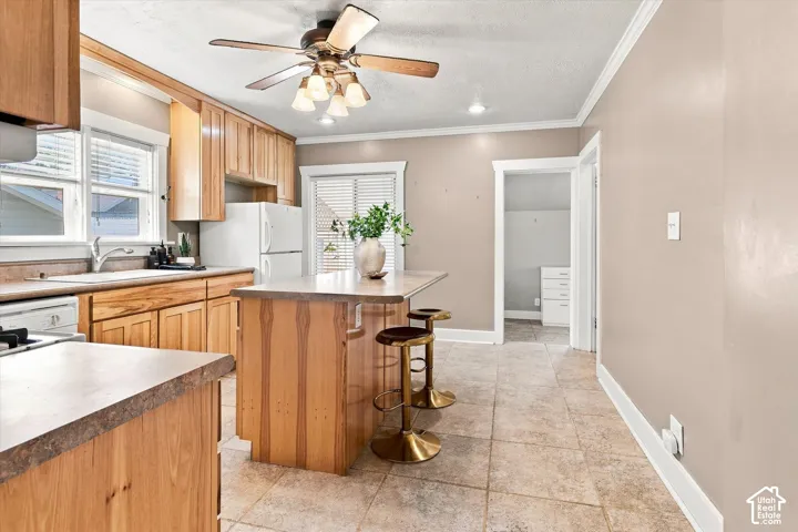 Spacious kitchen featuring warm wood cabinetry, stainless steel appliances, and a multi-level island with seating
