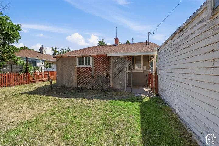 Spacious backyard with mature lawn and established landscaping, bordered by privacy fencing and neighboring structures