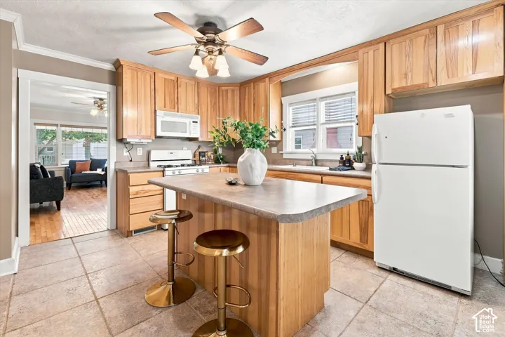 Warm wood cabinetry frames this well-appointed kitchen, featuring a center island with seating, stainless steel appliances, and ample counter space
