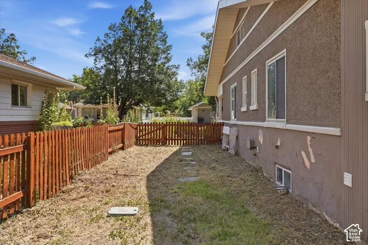 Fenced yard area featuring a picket fence and stepping stones