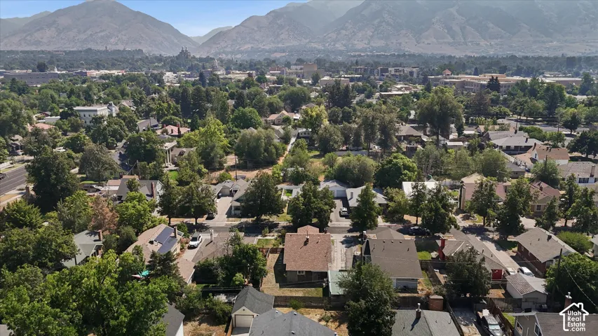 Residential neighborhood with mature tree canopy, surrounded by distant mountains