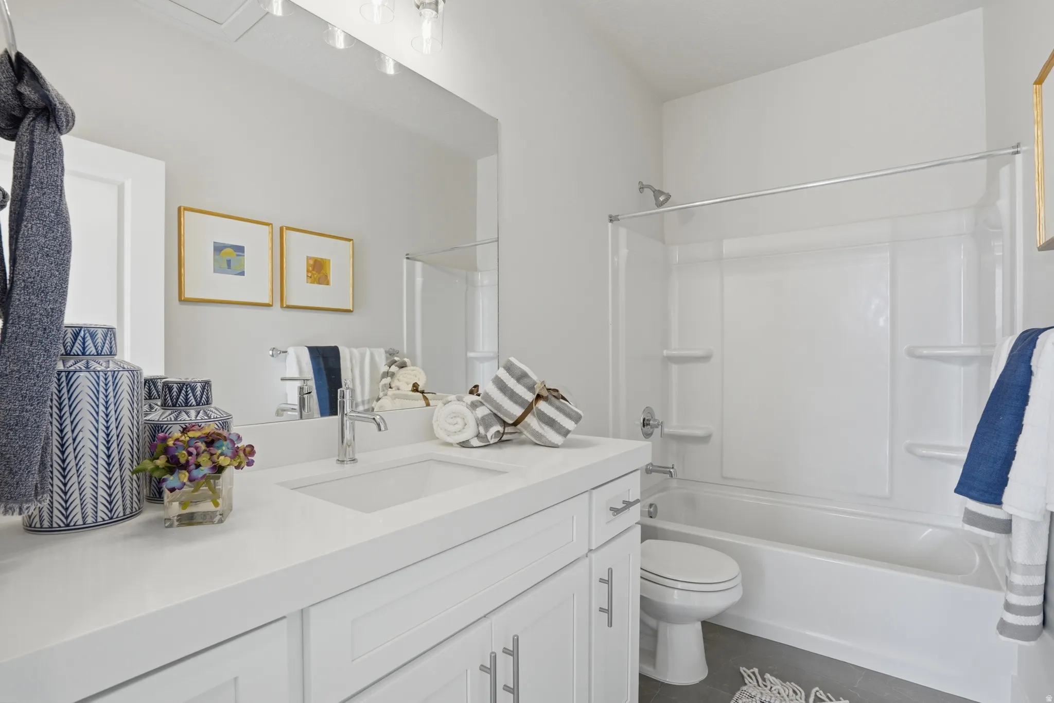 Bathroom featuring a white vanity with an integrated sink, polished chrome faucet, and white shaker-style cabinetry