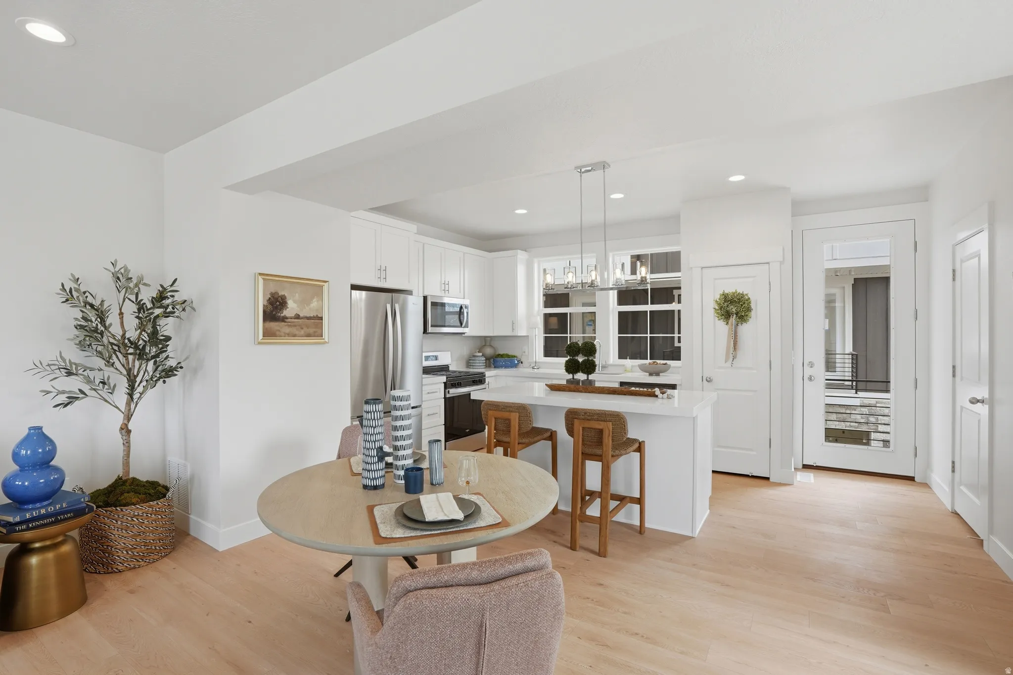 Open-concept kitchen and dining area featuring light wood-finish flooring