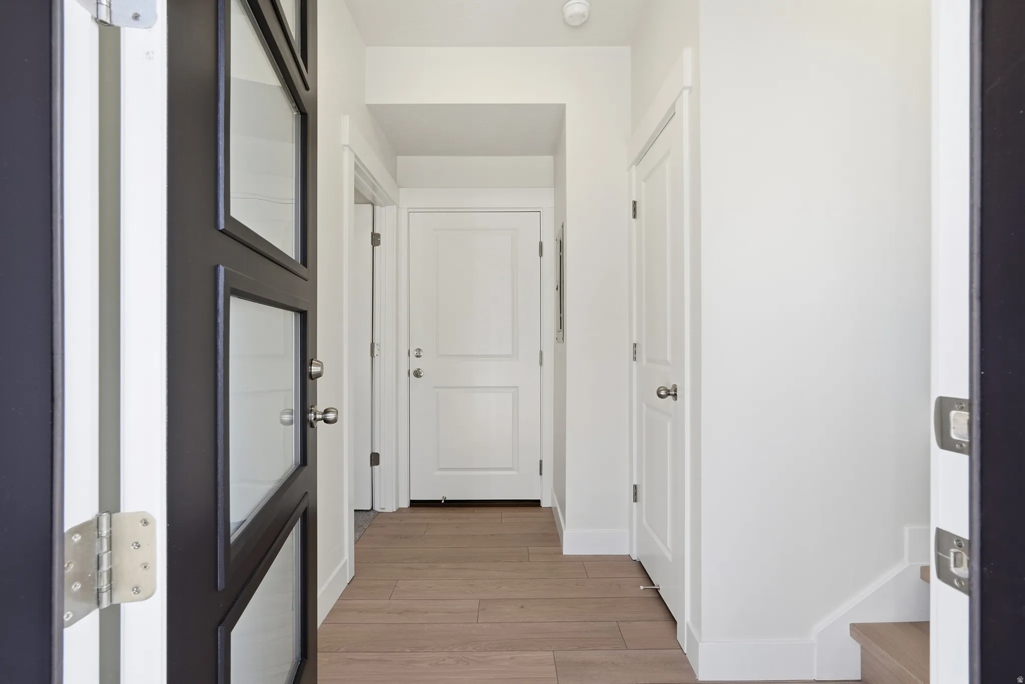 Entryway featuring a dark paneled door with multiple glass inserts and brushed nickel hardware