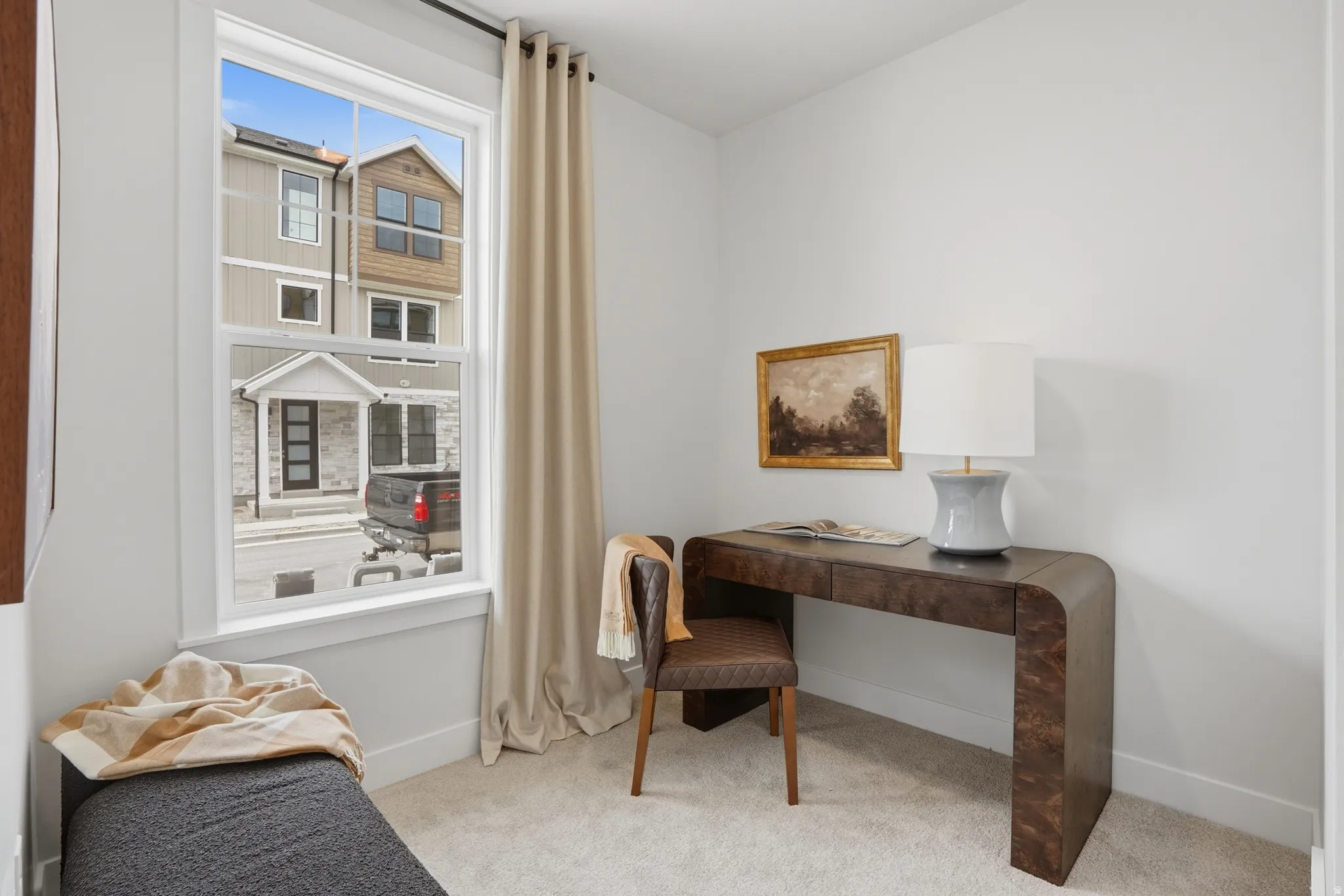 Windowed room featuring light-toned carpeting and neutral wall paint