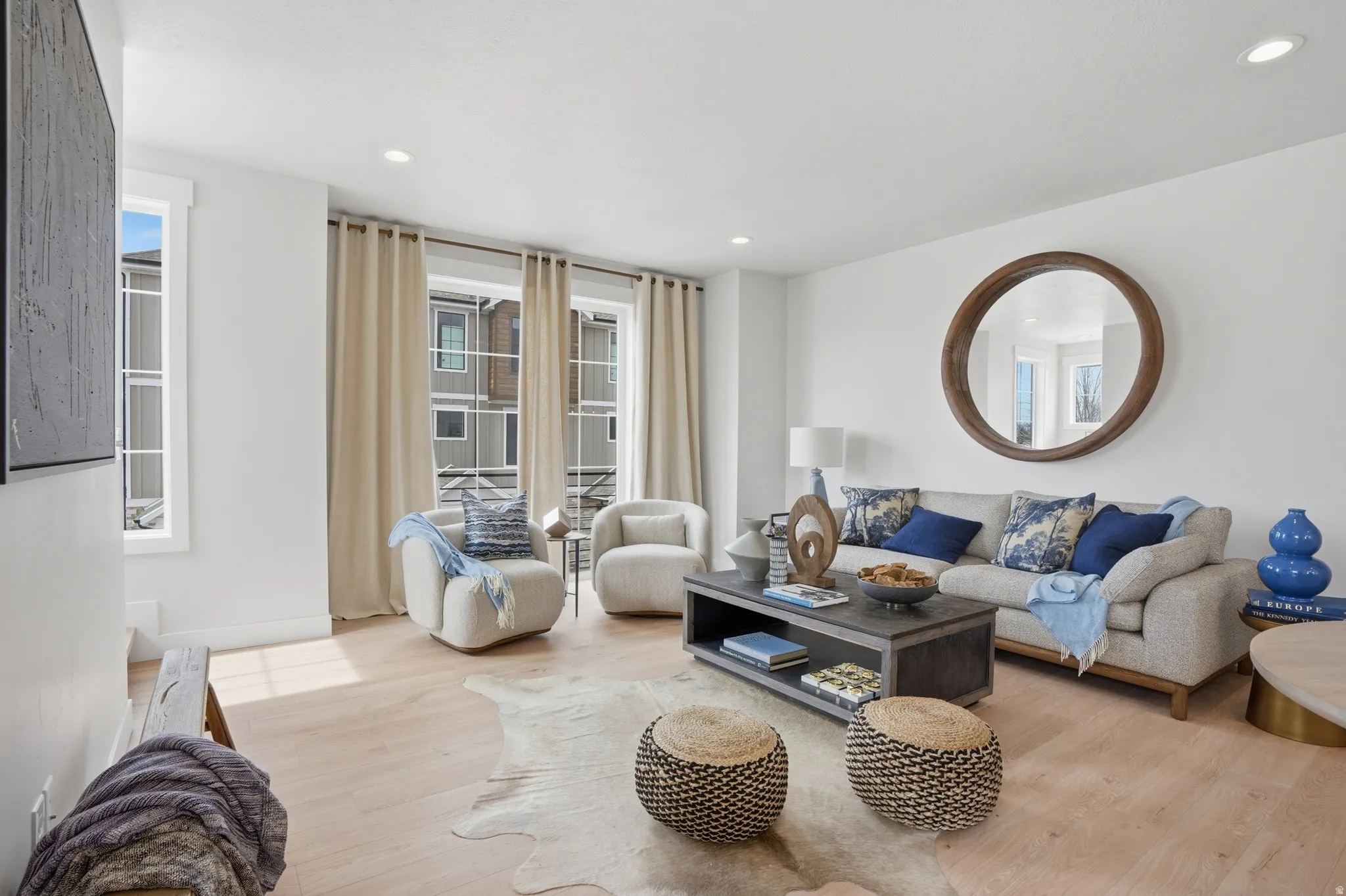 Living area featuring light wood-finish flooring and recessed lighting