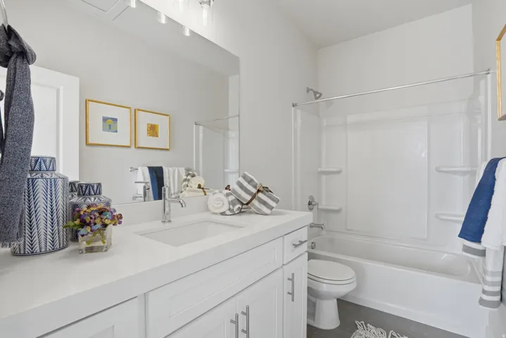 Bathroom featuring a white vanity with an integrated sink, polished chrome faucet, and white shaker-style cabinetry