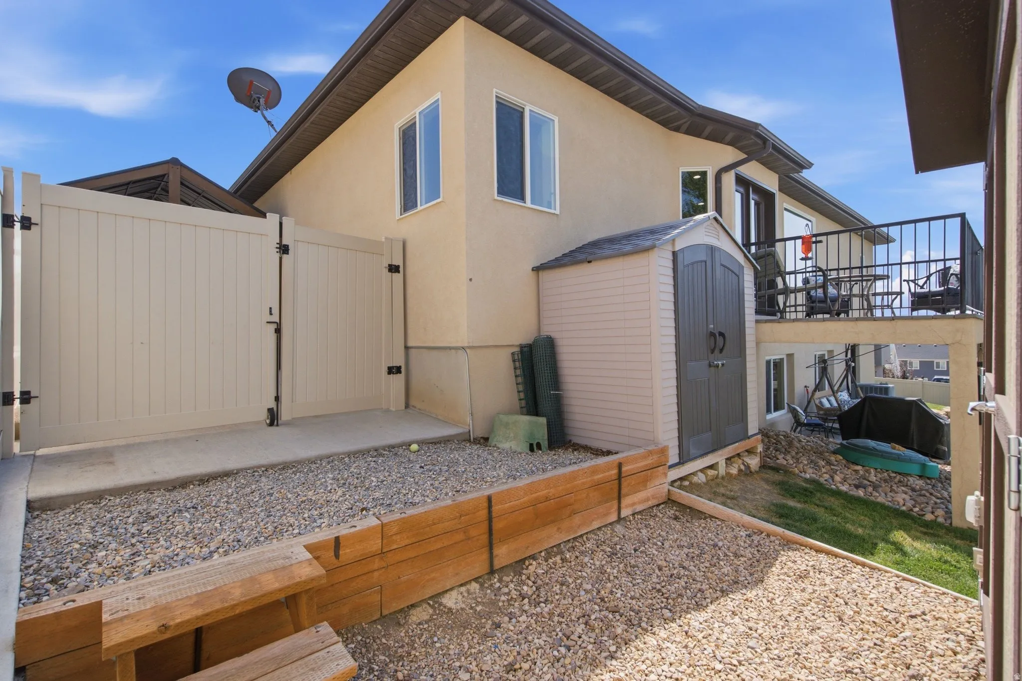 Modern home featuring a thoughtfully designed outdoor living space with composite decking, gravel landscaping, and metal railings
