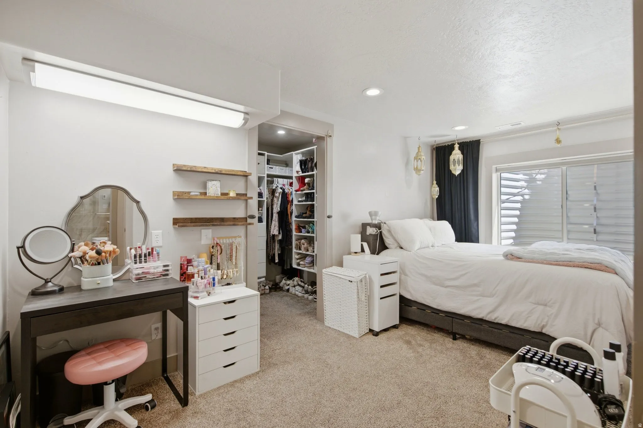Spacious primary bedroom suite featuring a neutral color palette, carpeted flooring, and abundant natural light from multi-panel sliding glass doors