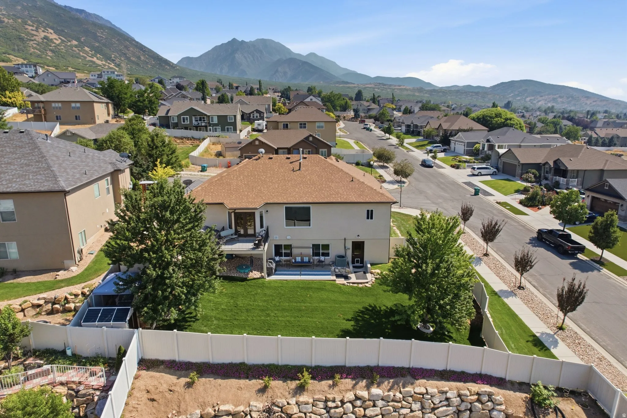Stunning contemporary home showcasing a professionally landscaped backyard with mature trees, manicured lawn, and modern hardscape elements