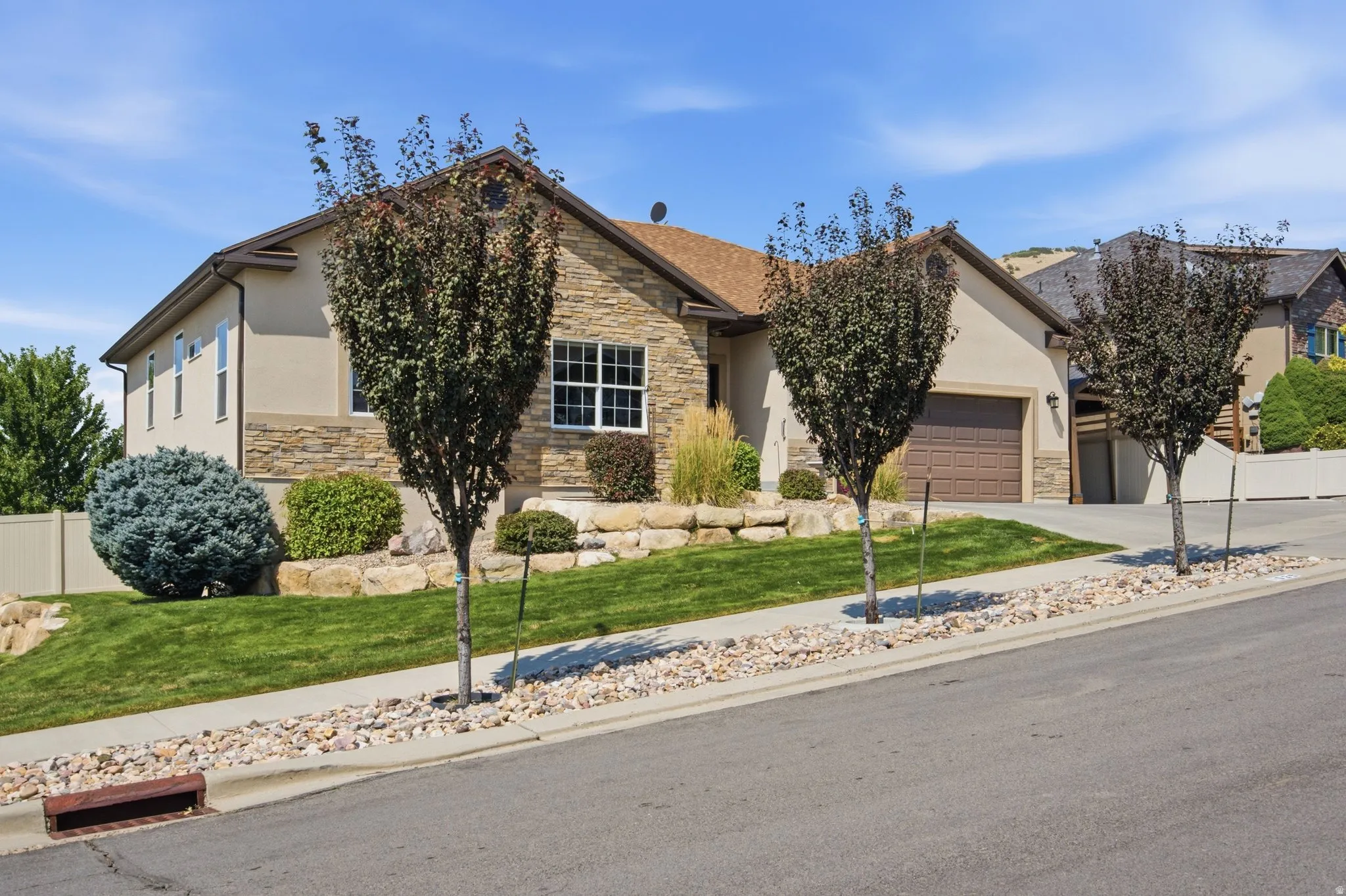 Charming single-story residence featuring a stucco and stone exterior with a pitched roof and architectural detailing