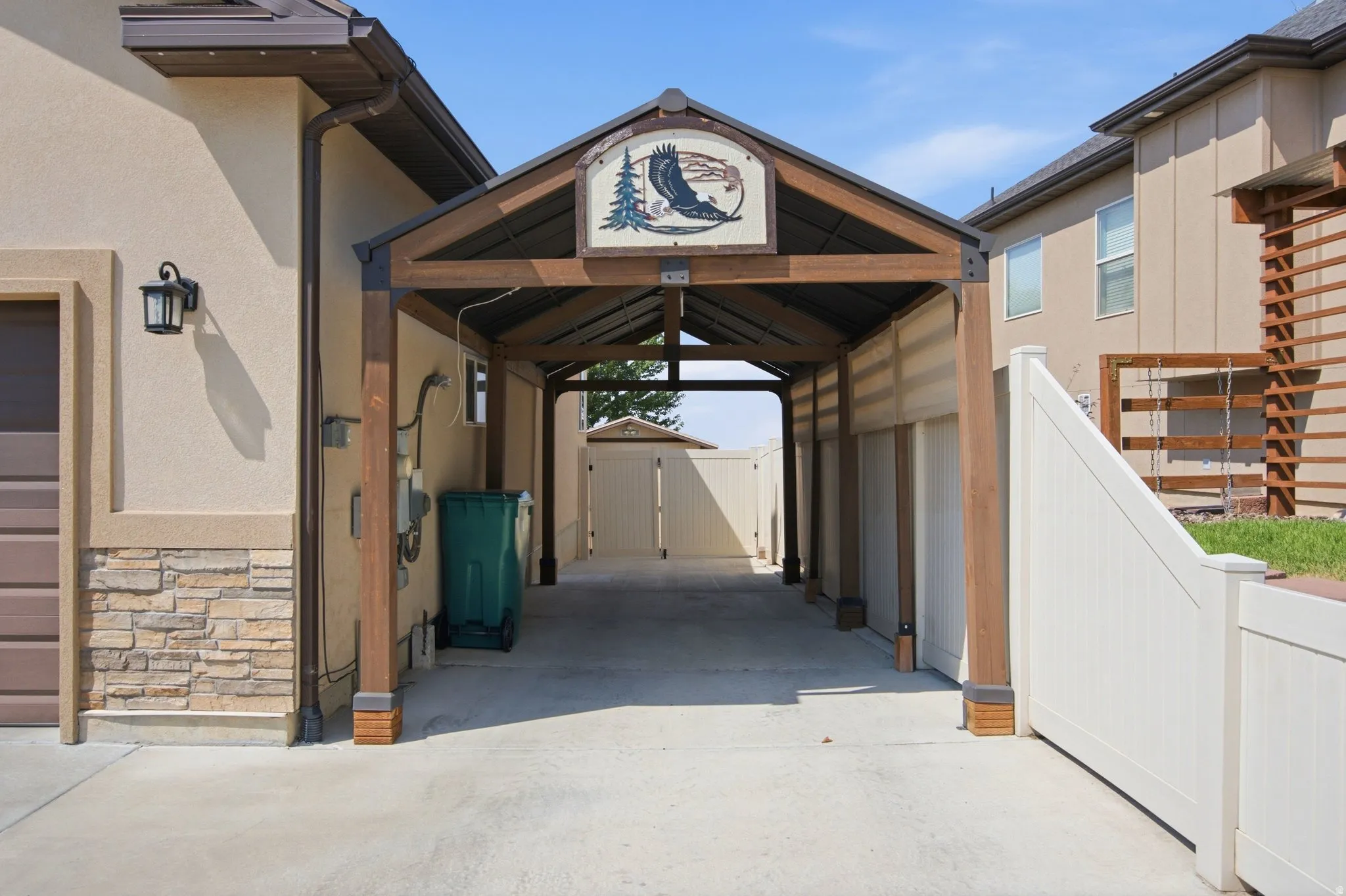 Covered breezeway with timber-frame architectural detailing and peaked roofline, offering sheltered passage between structures