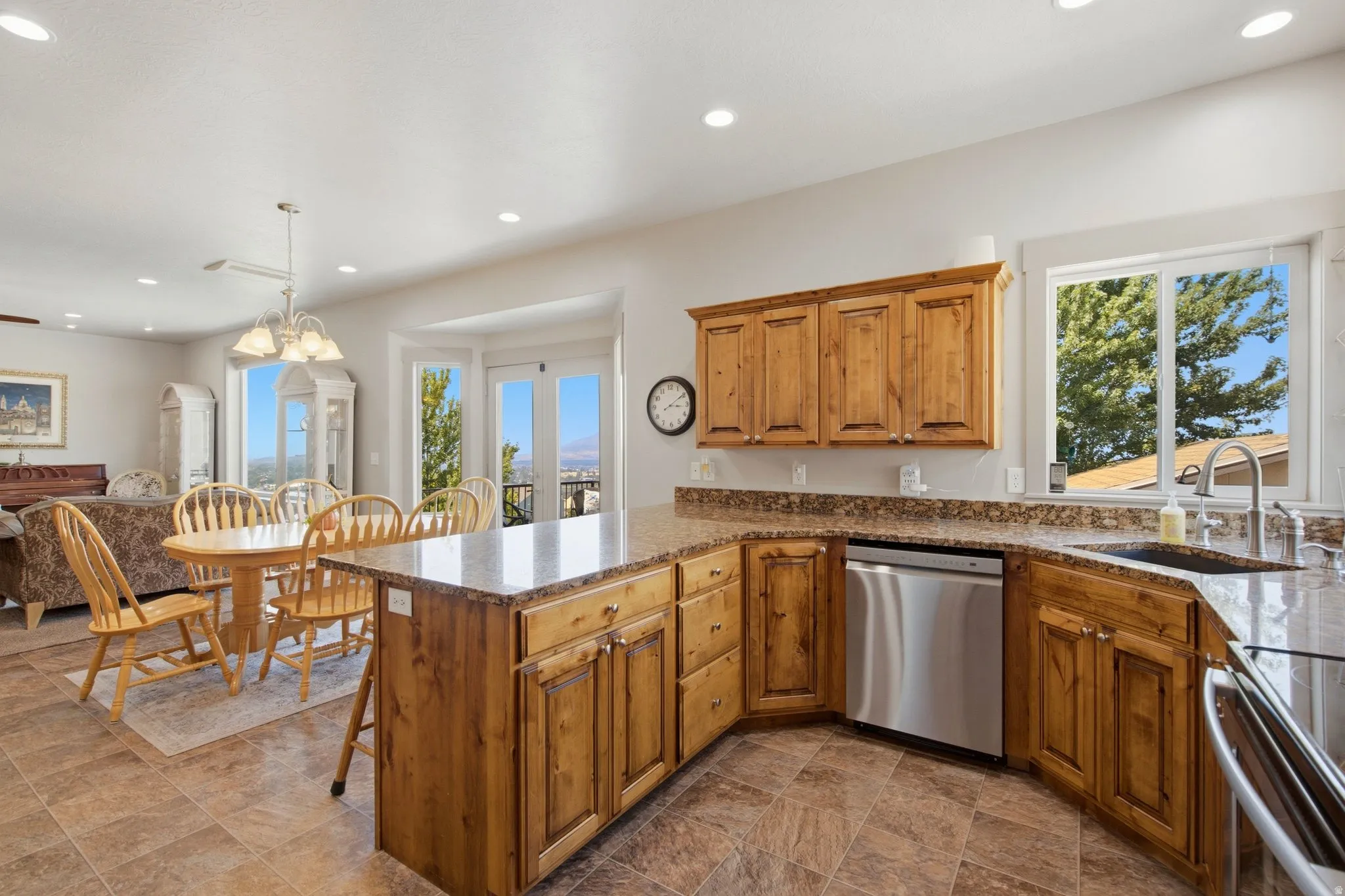 Gourmet kitchen featuring warm wood cabinetry with detailed paneling, stainless steel appliances, granite countertops, and a large center island with seating