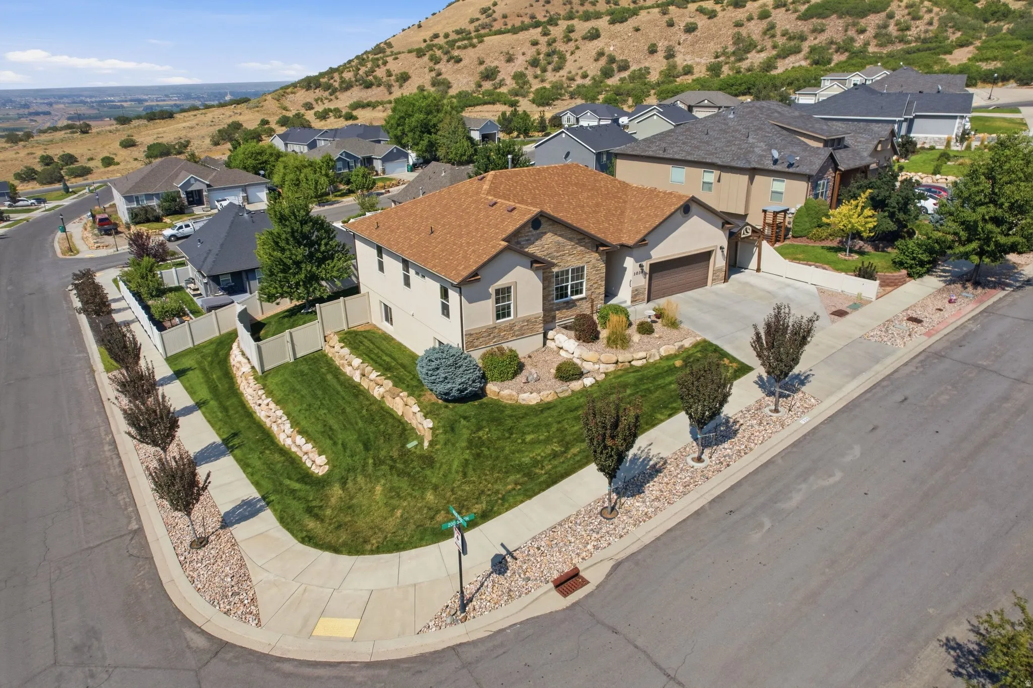 Elegant single-story residence featuring a warm-toned clay tile roof, stucco exterior, and curved driveway approach