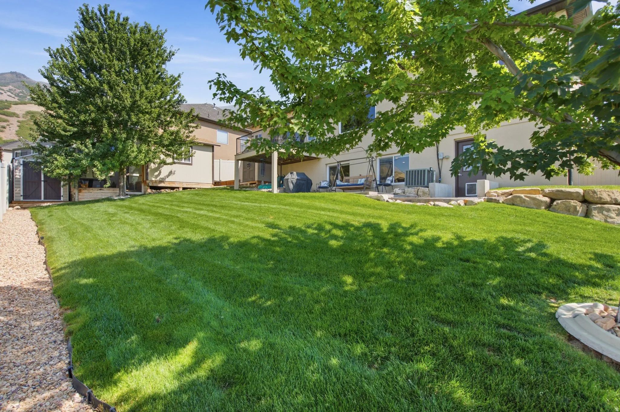 Expansive lawn with mature shade trees and manicured grounds, offering abundant outdoor space