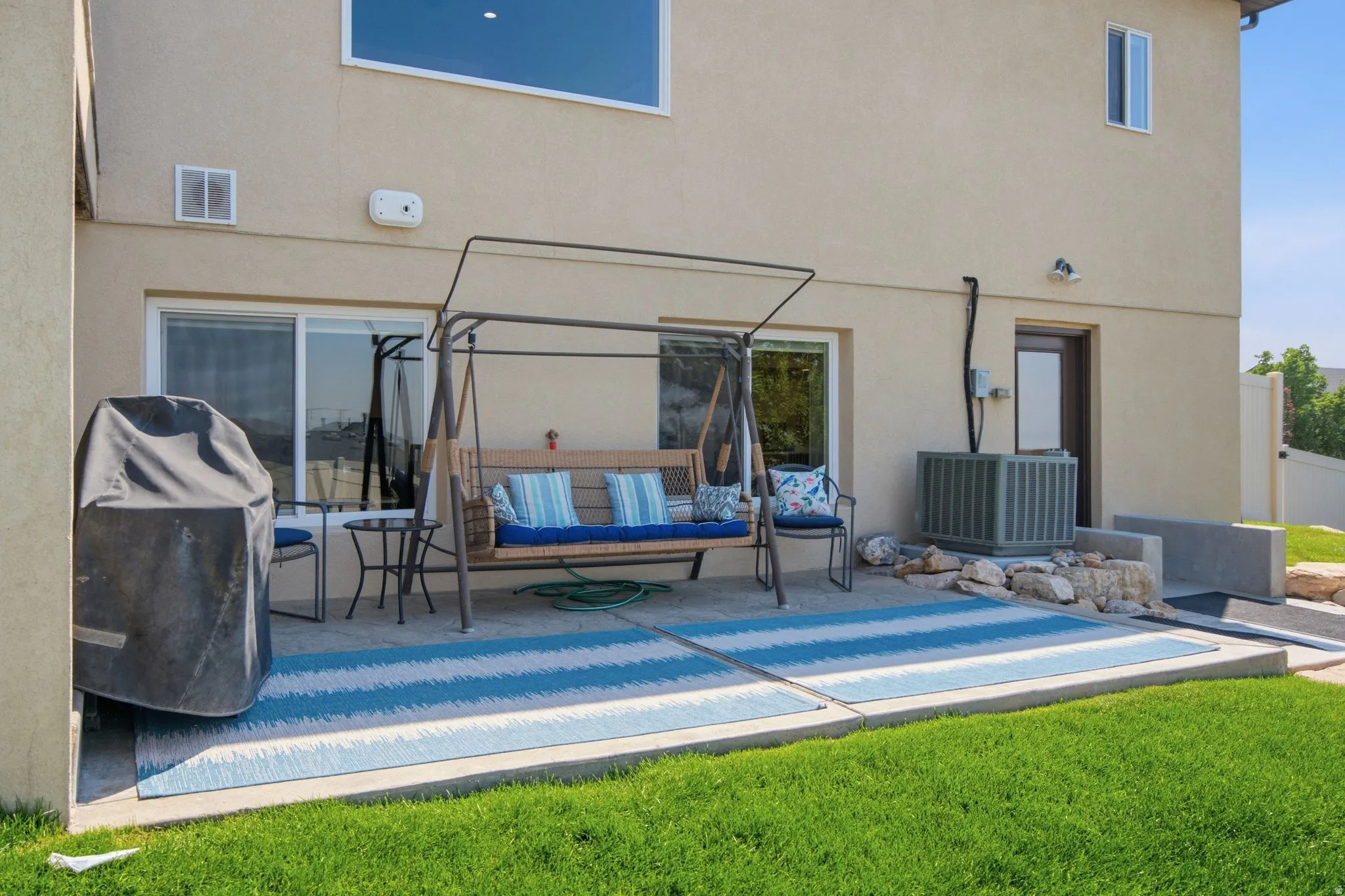 Expansive backyard oasis featuring a sparkling saltwater pool with integrated lounging area, stamped concrete decking, metal pergola with integrated shade structure, and manicured lawn