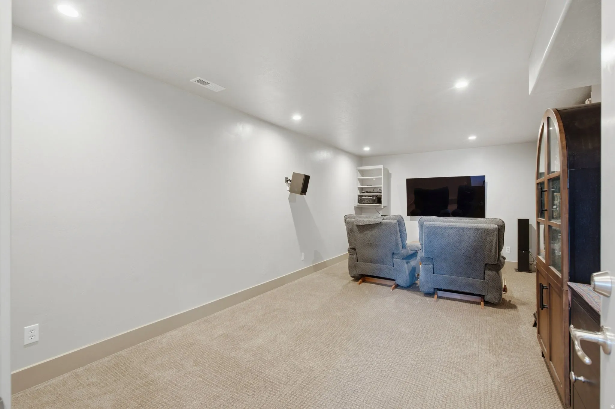 Carpeted room with recessed lighting and a built-in media console