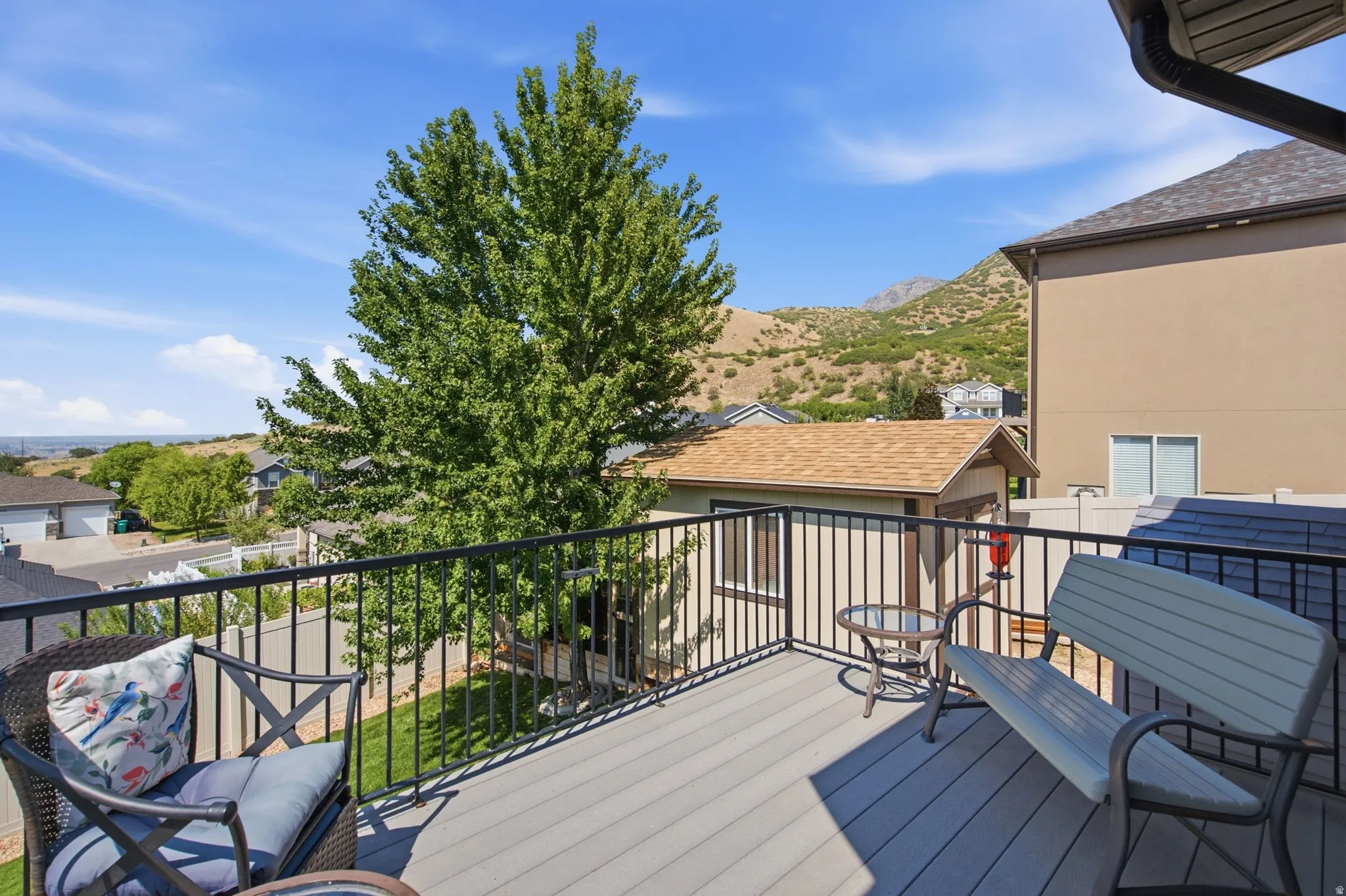 Expansive composite deck featuring mixed decking materials, black aluminum railing with horizontal pickets, and built-in seating areas