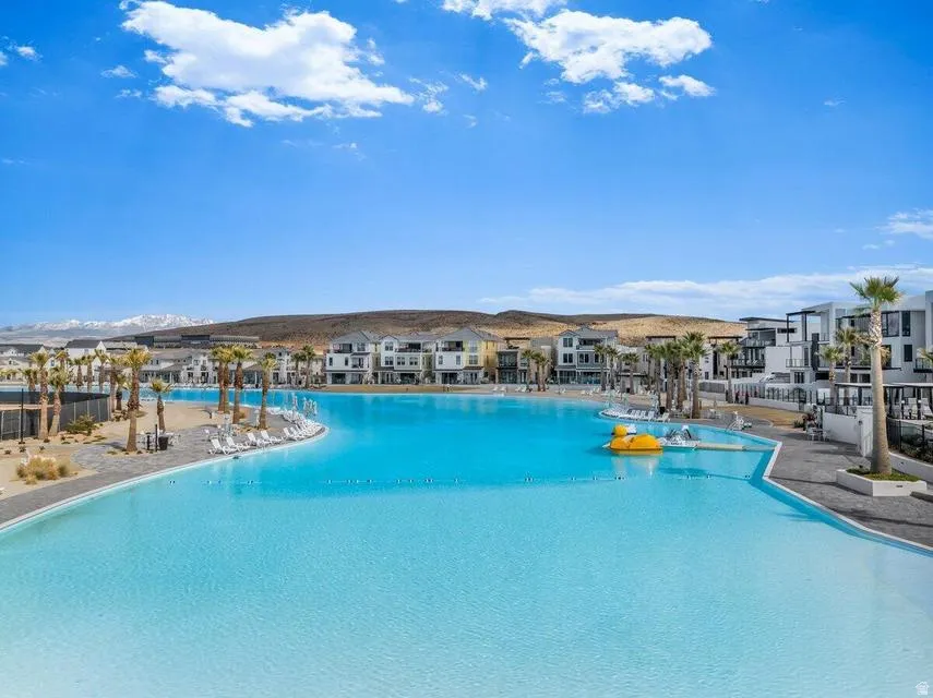 Expansive lagoon-style pool with surrounding sandy shores and modern residences