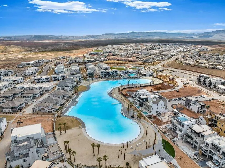Expansive lagoon-style pool with sandy beach areas and surrounding residences
