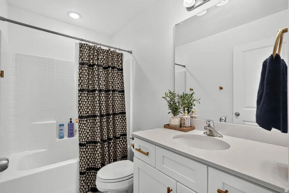 Spa-inspired bathroom featuring a clean-lined vanity with dual sinks, quartz countertop, and brass hardware