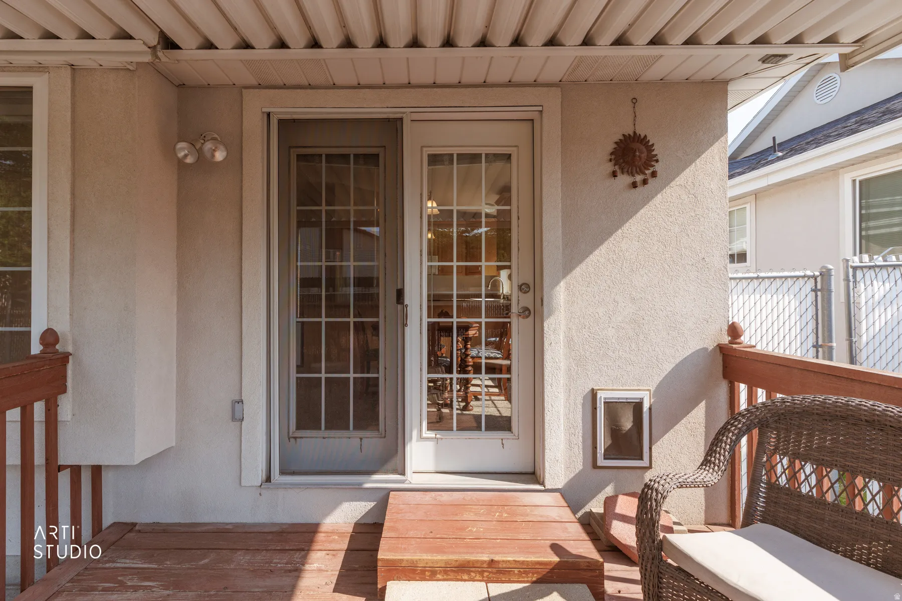 Covered deck featuring wood-finish flooring, French doors with multi-pane glass panels, and a built-in pet door