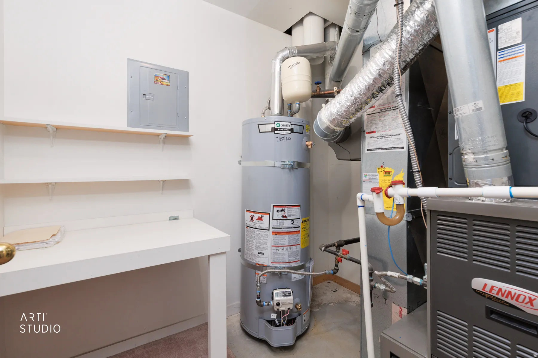 Utility room featuring a tall gas water heater with insulated piping, built-in white cabinetry with open shelving, and HVAC system components