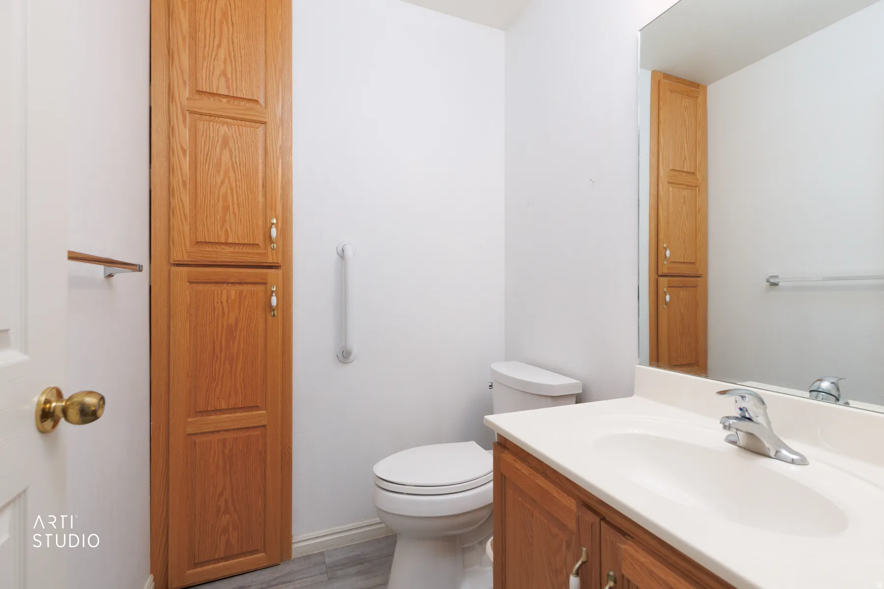 Clean and functional bathroom featuring a wood-finish vanity with an integrated sink, white quartz countertop, chrome faucet, and ample mirror space