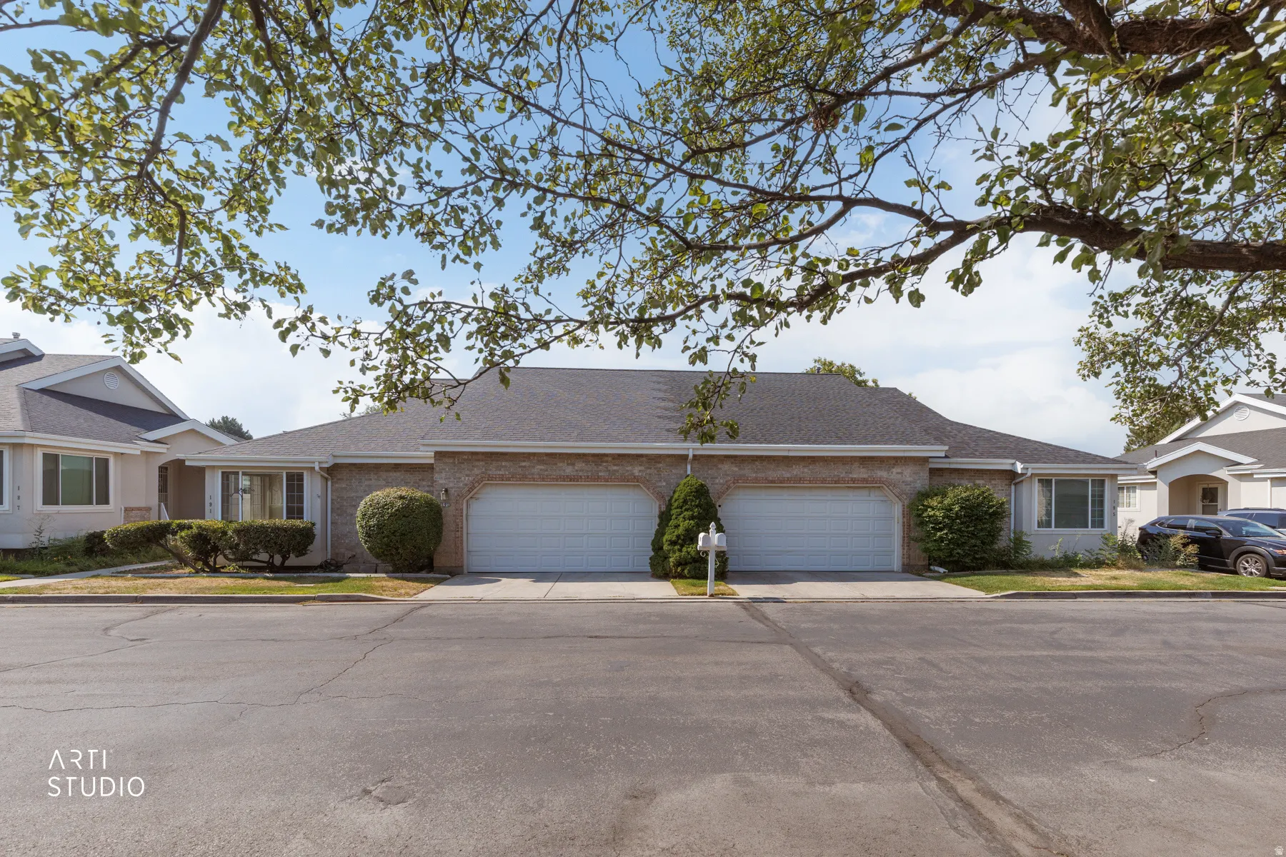 Elegant duplex featuring dual two-car garage doors with clean-lined architectural design