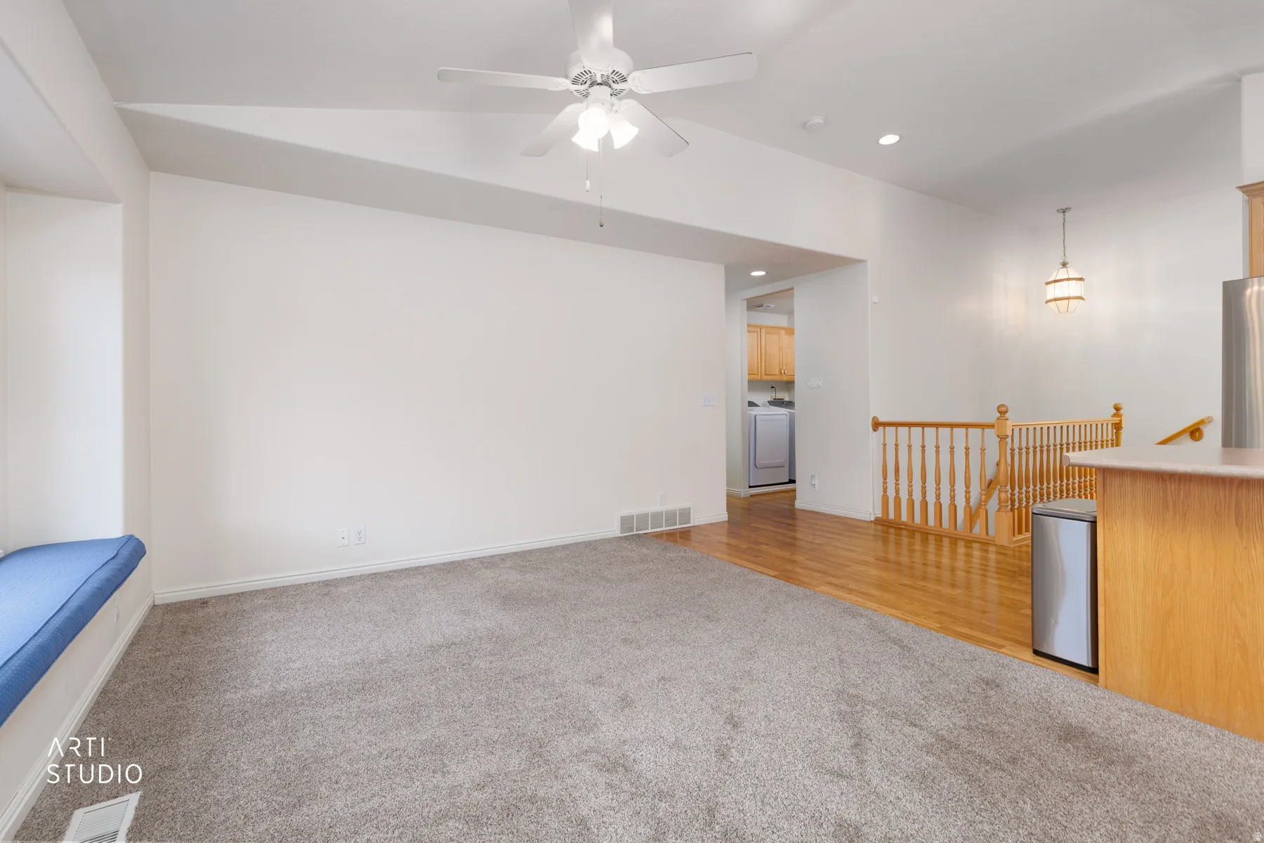 Spacious open-concept living area featuring neutral carpeting, recessed lighting, and a ceiling fan