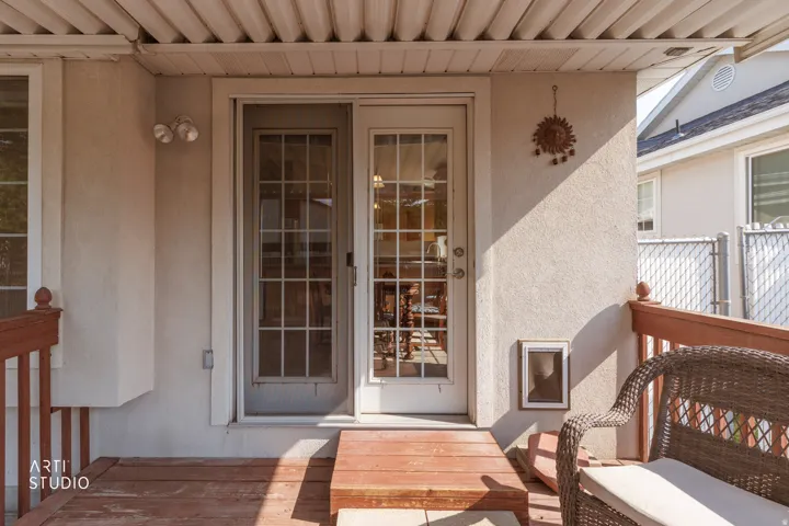 Covered deck featuring wood-finish flooring, French doors with multi-pane glass panels, and a built-in pet door