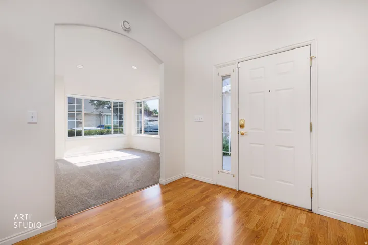 Spacious bedroom with hardwood flooring and abundant natural light from large bay window