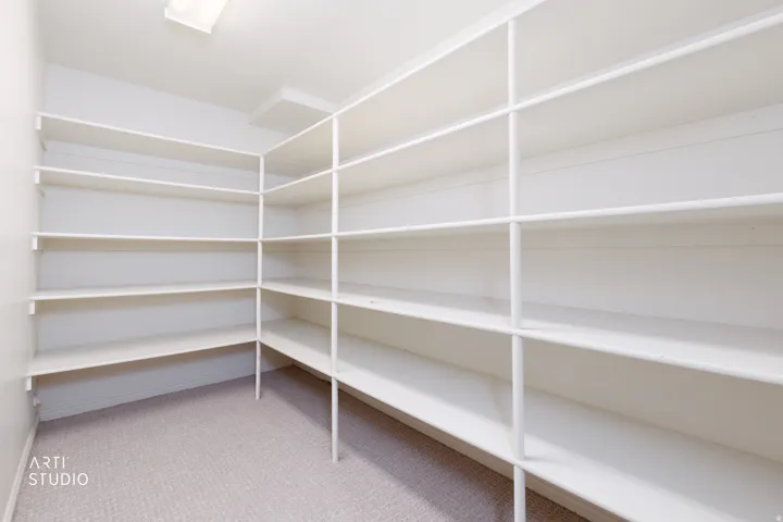 Spacious storage room featuring extensive built-in shelving with white metal framework and multiple tiers throughout