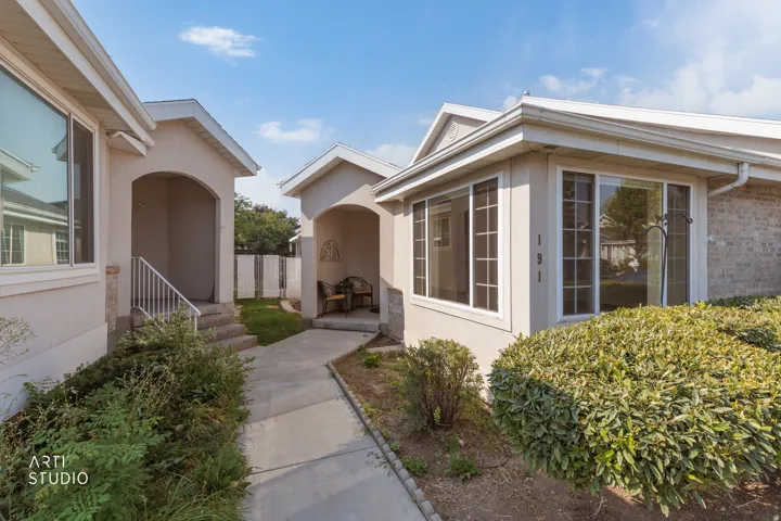 Exterior stucco siding with brick accents and multiple large windows