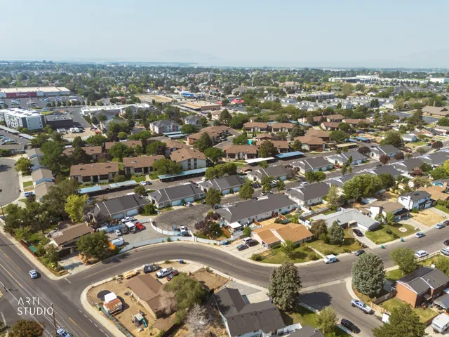 Aerial view showcasing a well-planned residential community with tree-lined streets, single-family homes featuring varied architectural styles, and established landscaping throughout the neighborhood