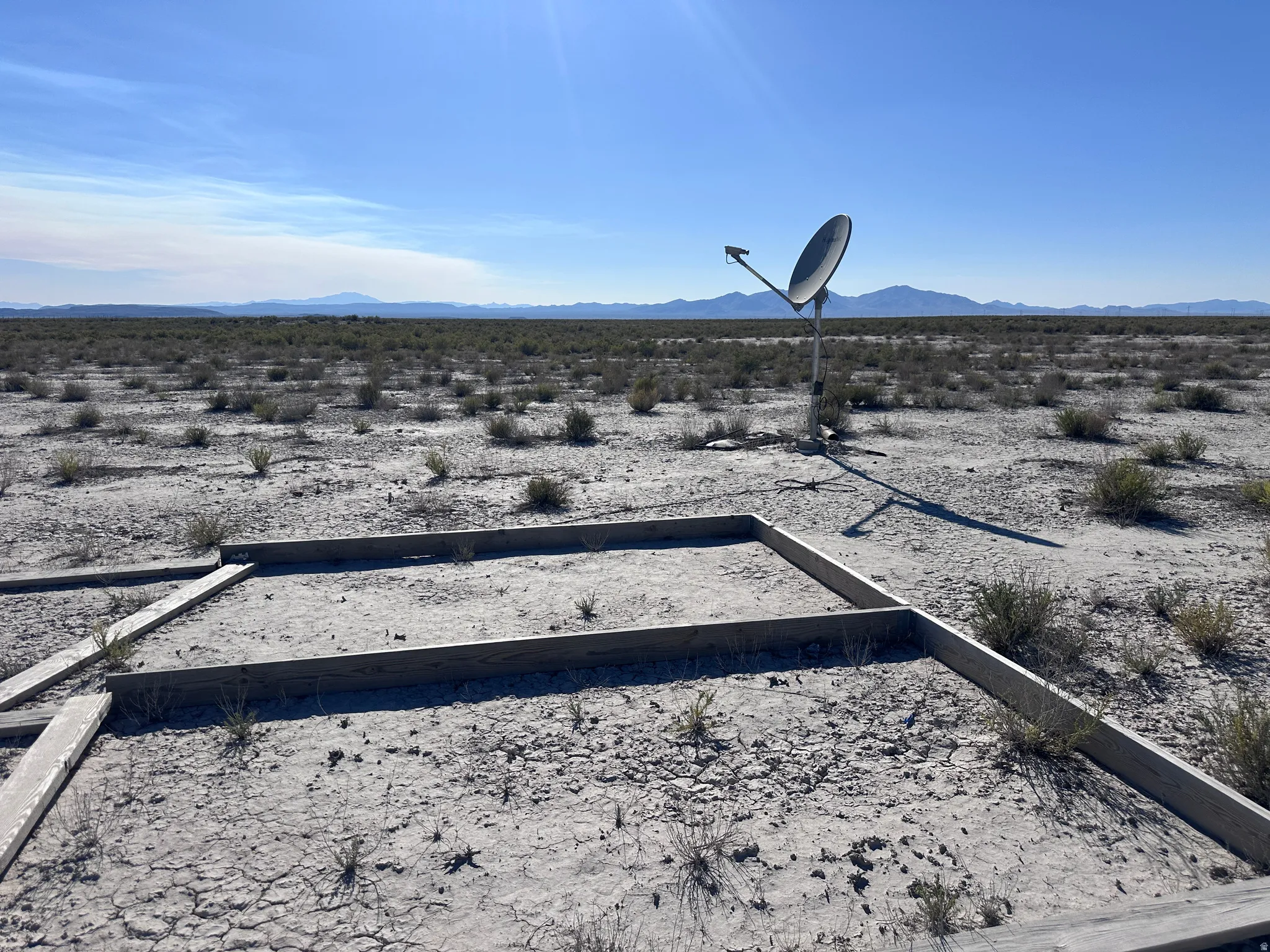 Expansive desert landscape with distant mountains under a clear sky