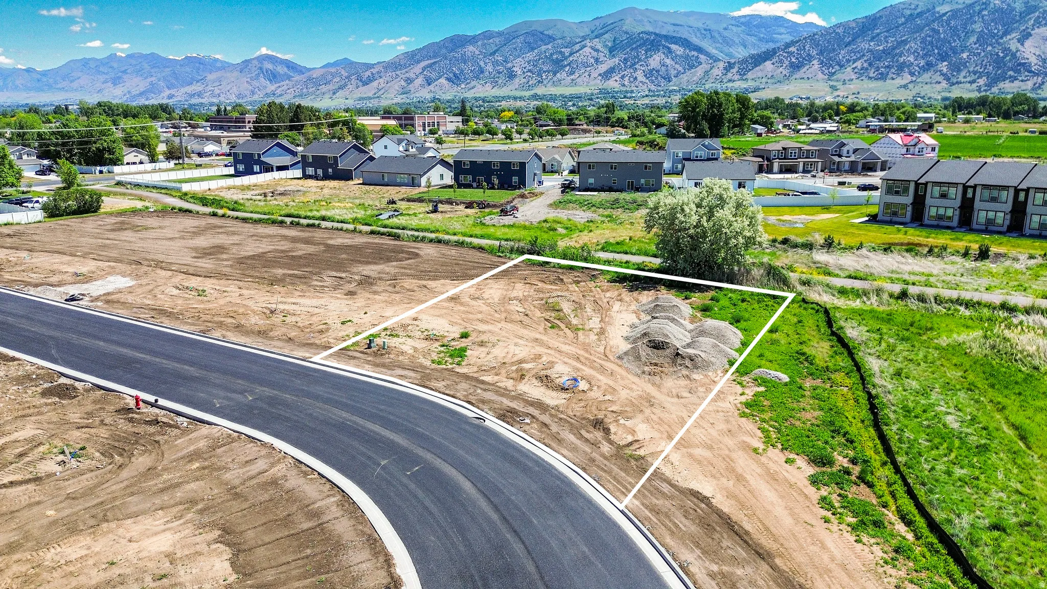 Developable land parcel featuring a paved road frontage and surrounding natural terrain