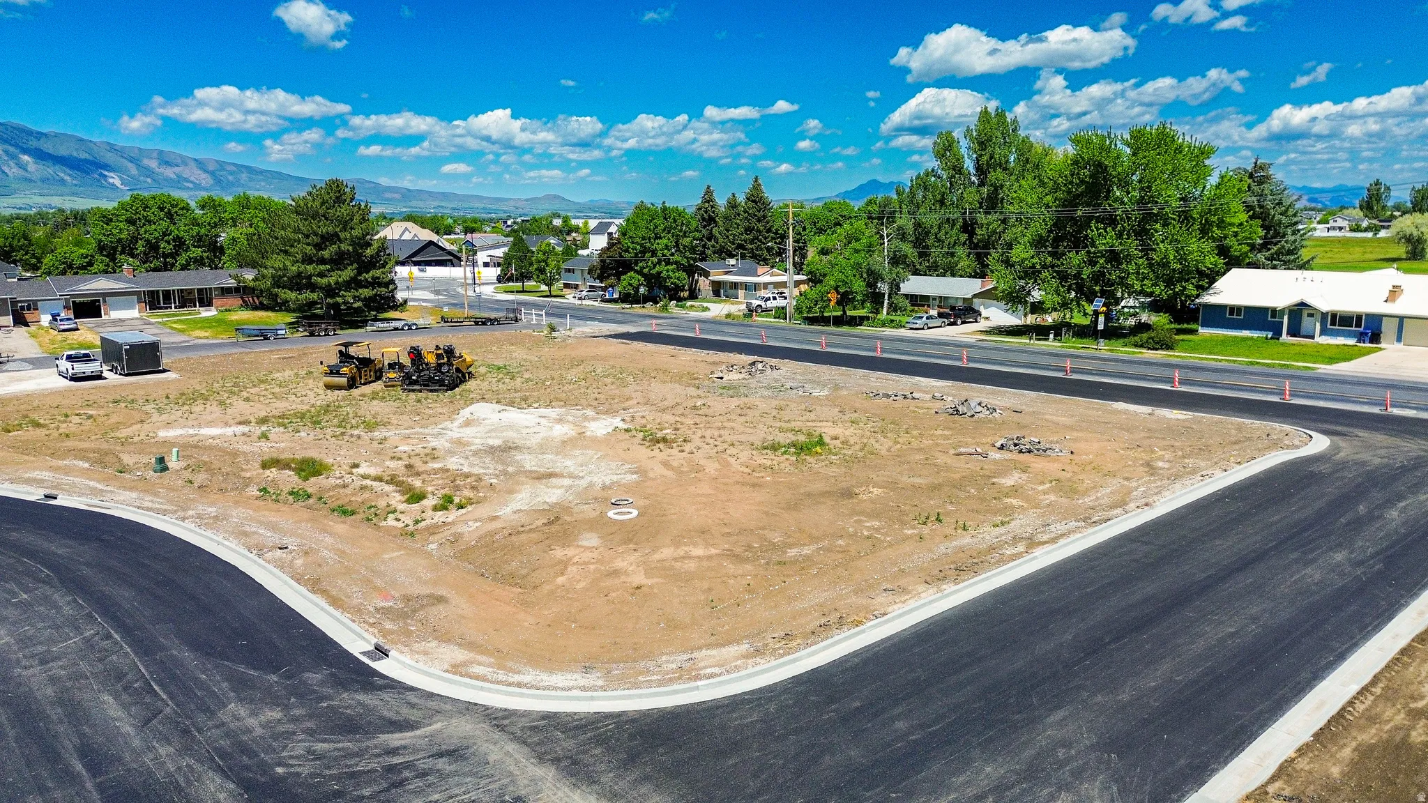 Cleared residential lot featuring newly paved streets and concrete curbing