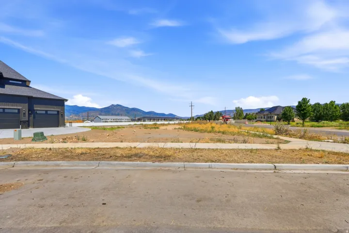 Cleared building lot with curb and sidewalk infrastructure